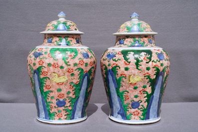 A pair of Chinese wucai 'galloping horses' vases and covers, Transitional period